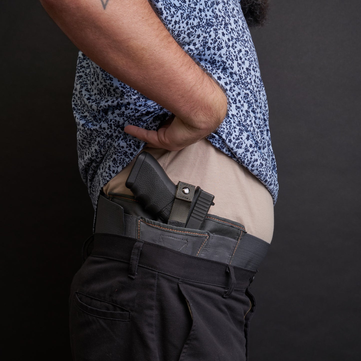 Side view of a man wearing the VNSH grey waist belt extender 20 inches attached to the VNSH grey Holster with a gun in it