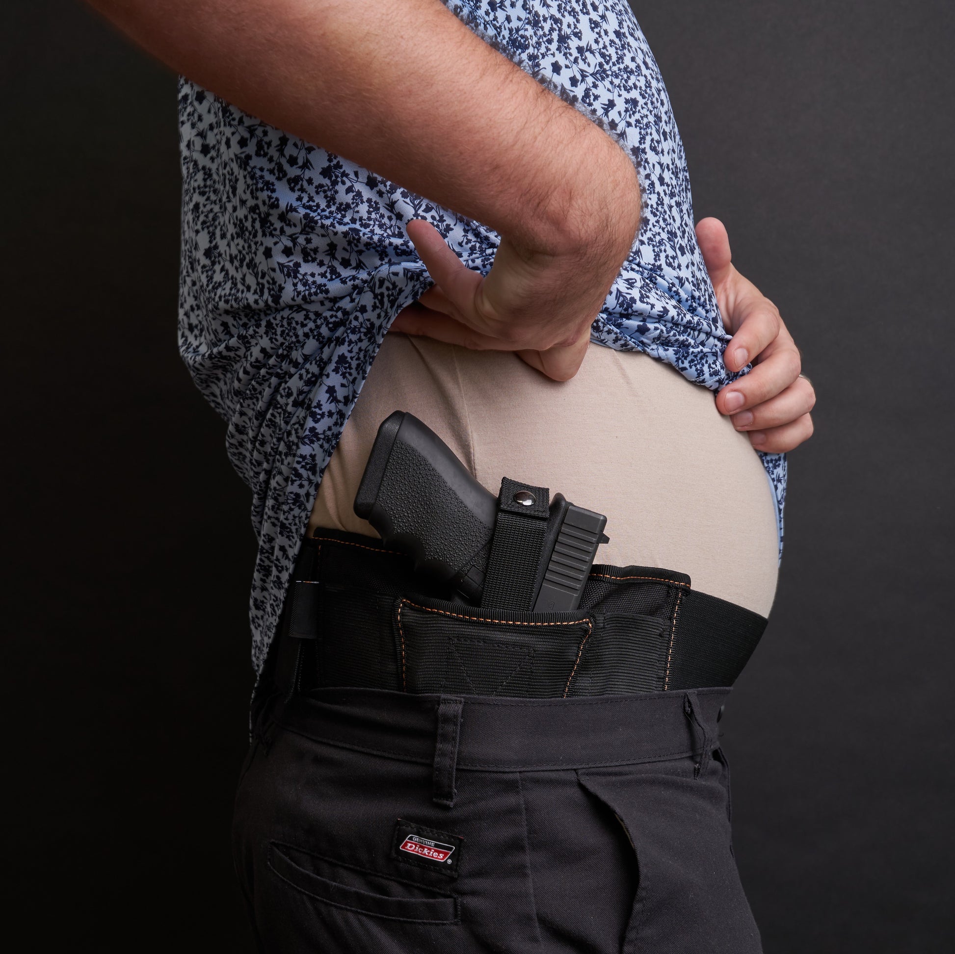 Side view of a man wearing the VNSH black waist belt extender 20 inches attached to the VNSH black Holster with a gun in it