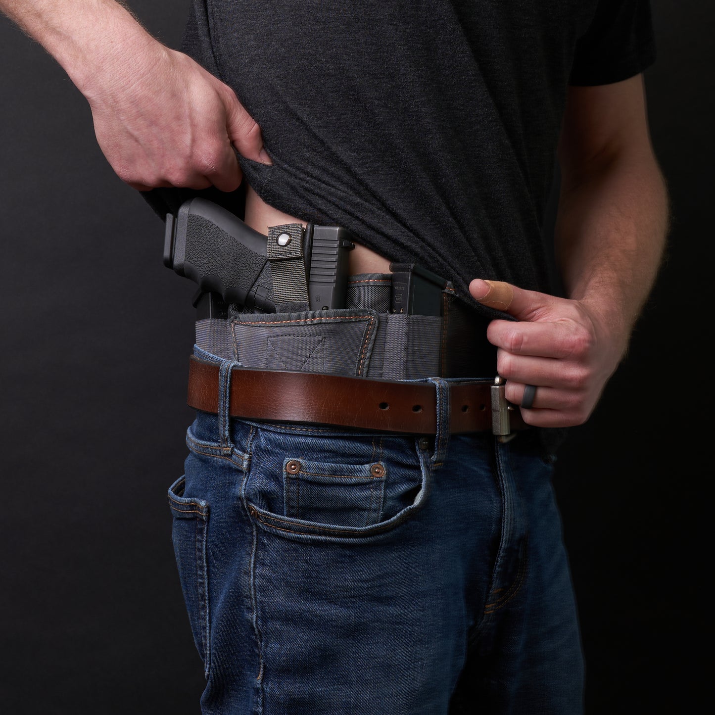 Side view of a man wearing the VNSH Grey Holster with a gun in it.