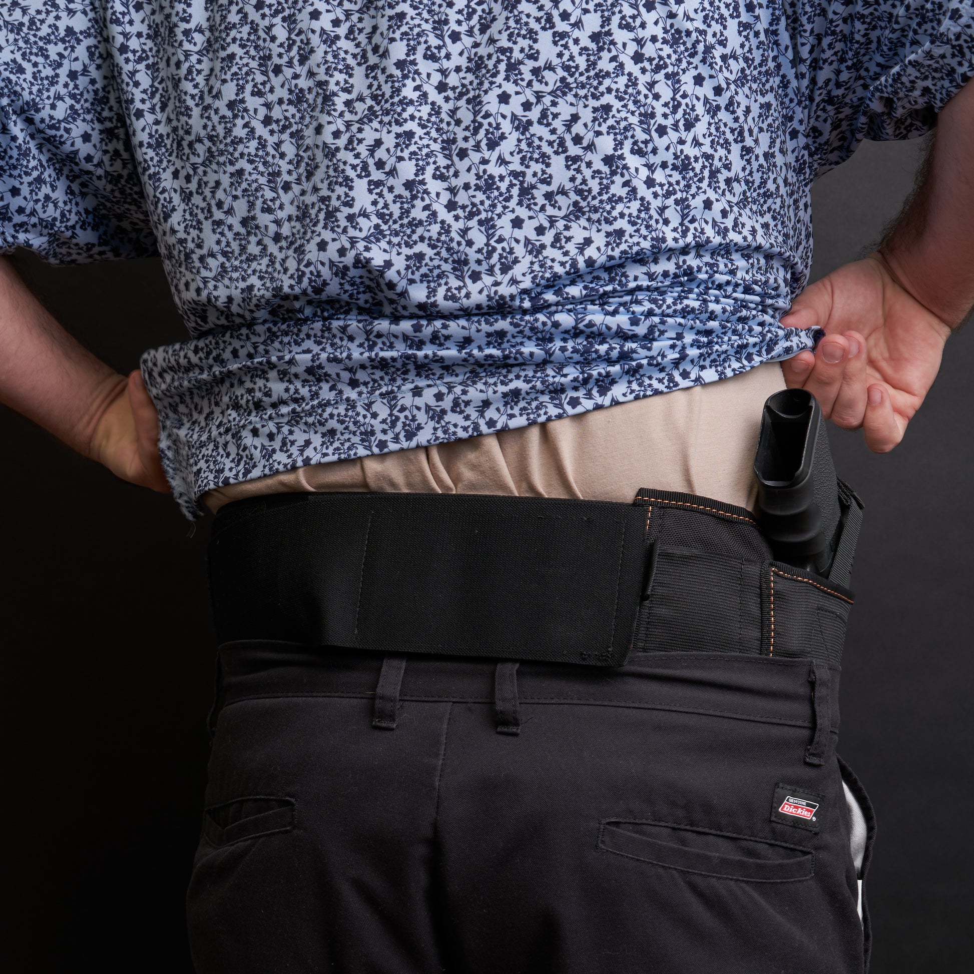 Back view of a man wearing the VNSH black waist belt extender 20 inches attached to the VNSH black Holster with a gun in it