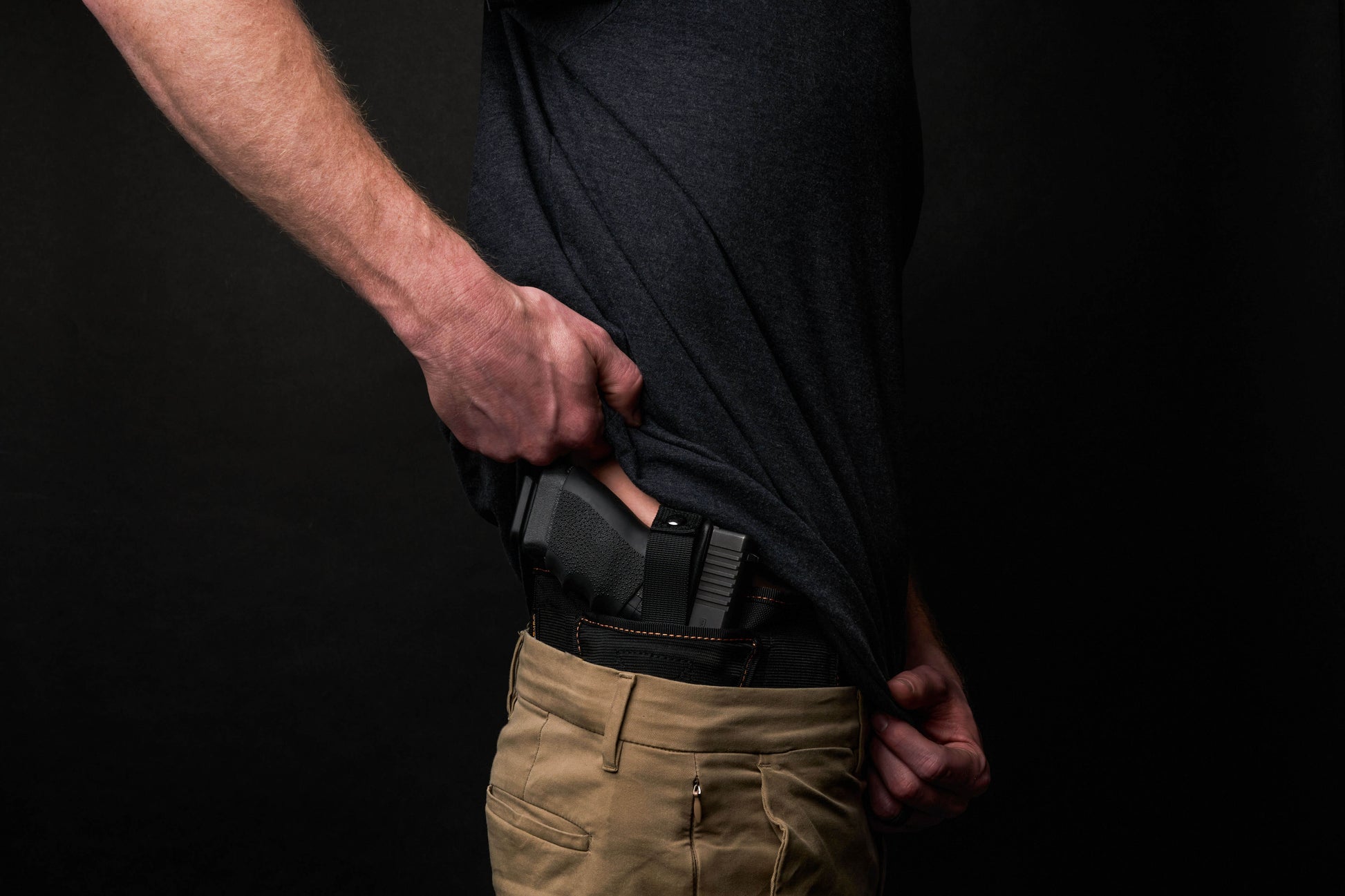 Sideview of a man wearing the VNSH Black Holster with a gun in it