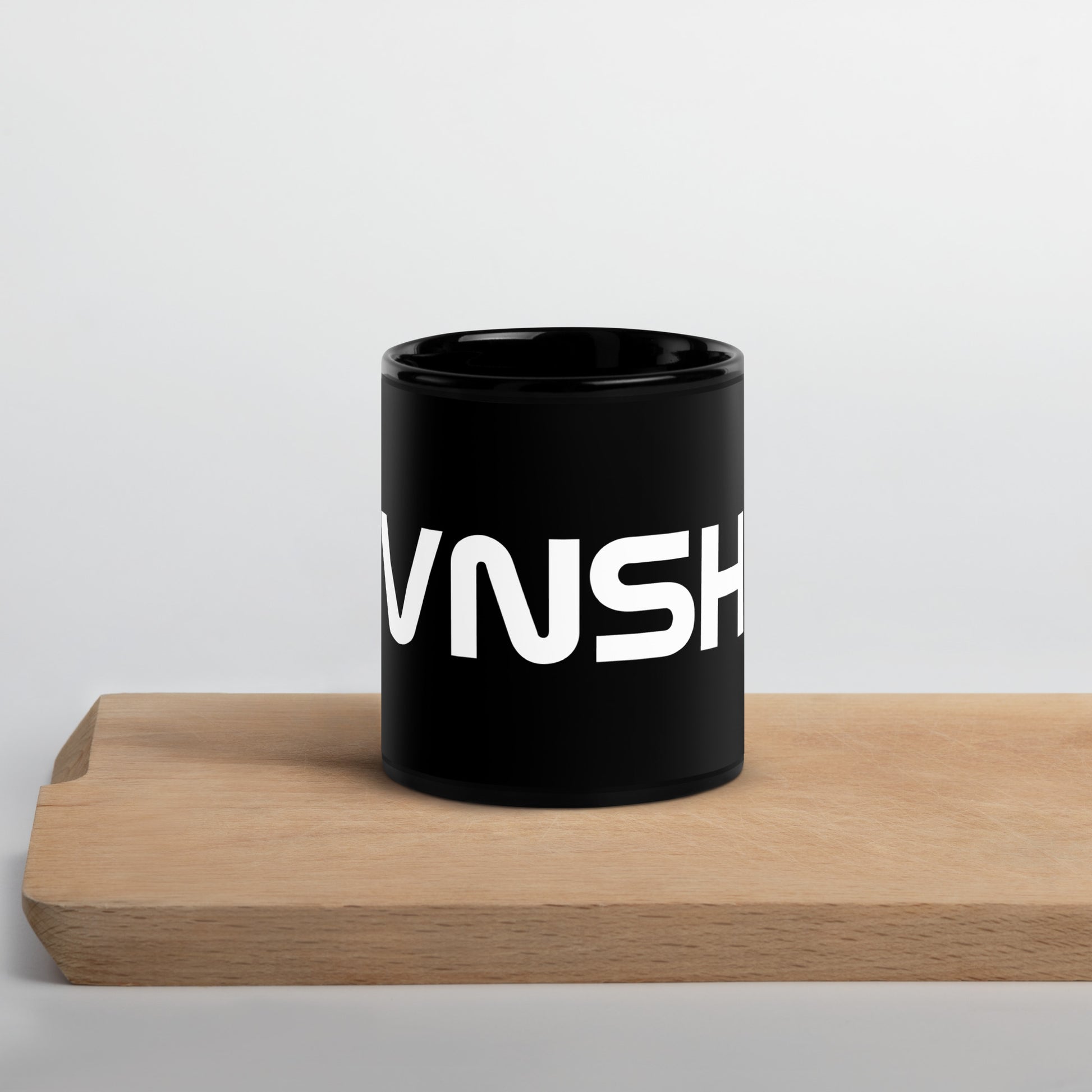 front view of black glossy 11oz mug with white VNSH logo